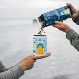 Pouring coffee beans into the Salmon Sisters canister by the ocean