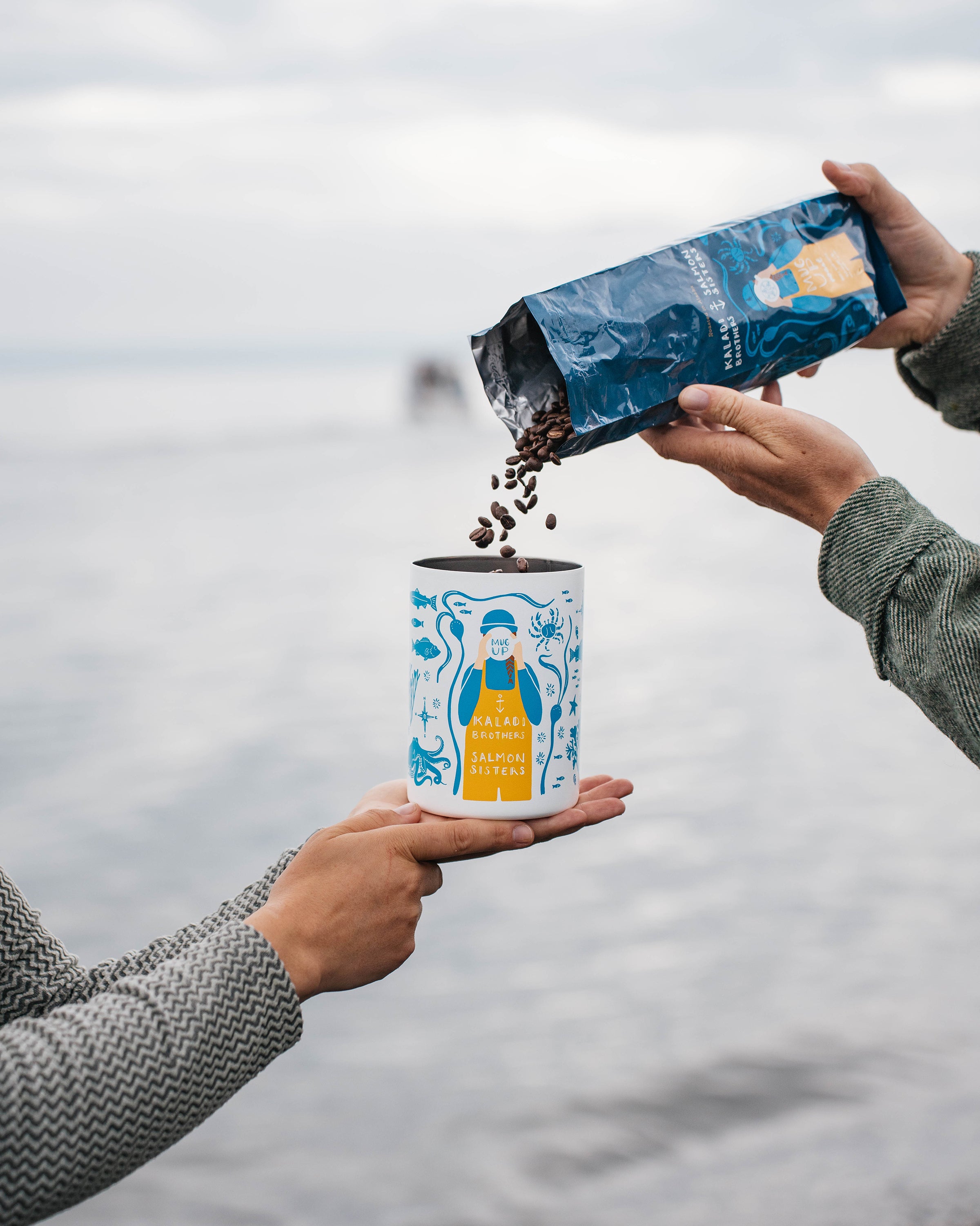 Pouring coffee beans into the Salmon Sisters canister by the ocean