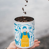 Coffee beans falling into the MiiR canister held in hand