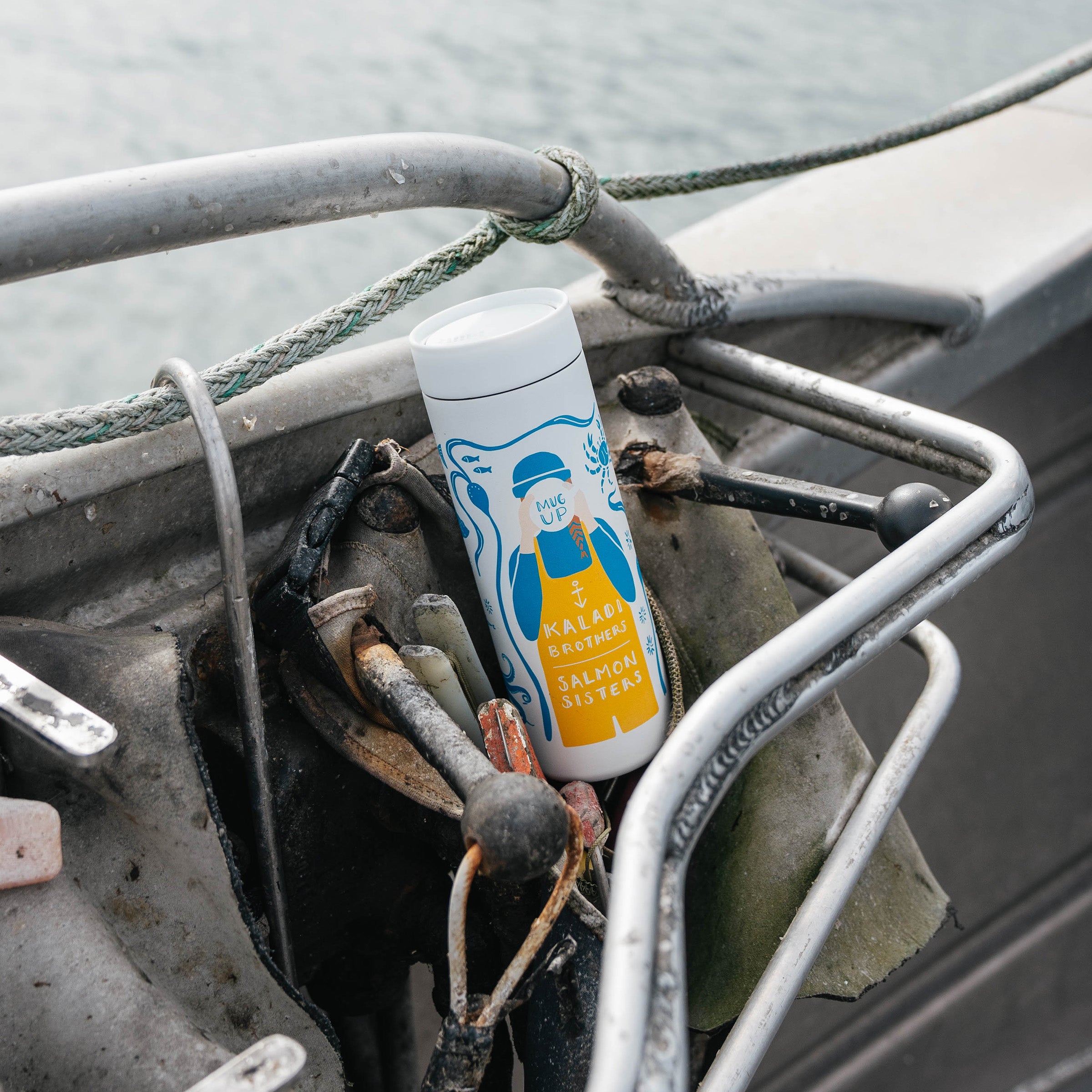 White 16oz 360 Traveler with Salmon Sisters artwork resting on boat rigging