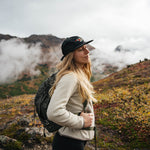 Hiker wearing the black Coffee Cherry Field Trip hat in misty Alaska mountains