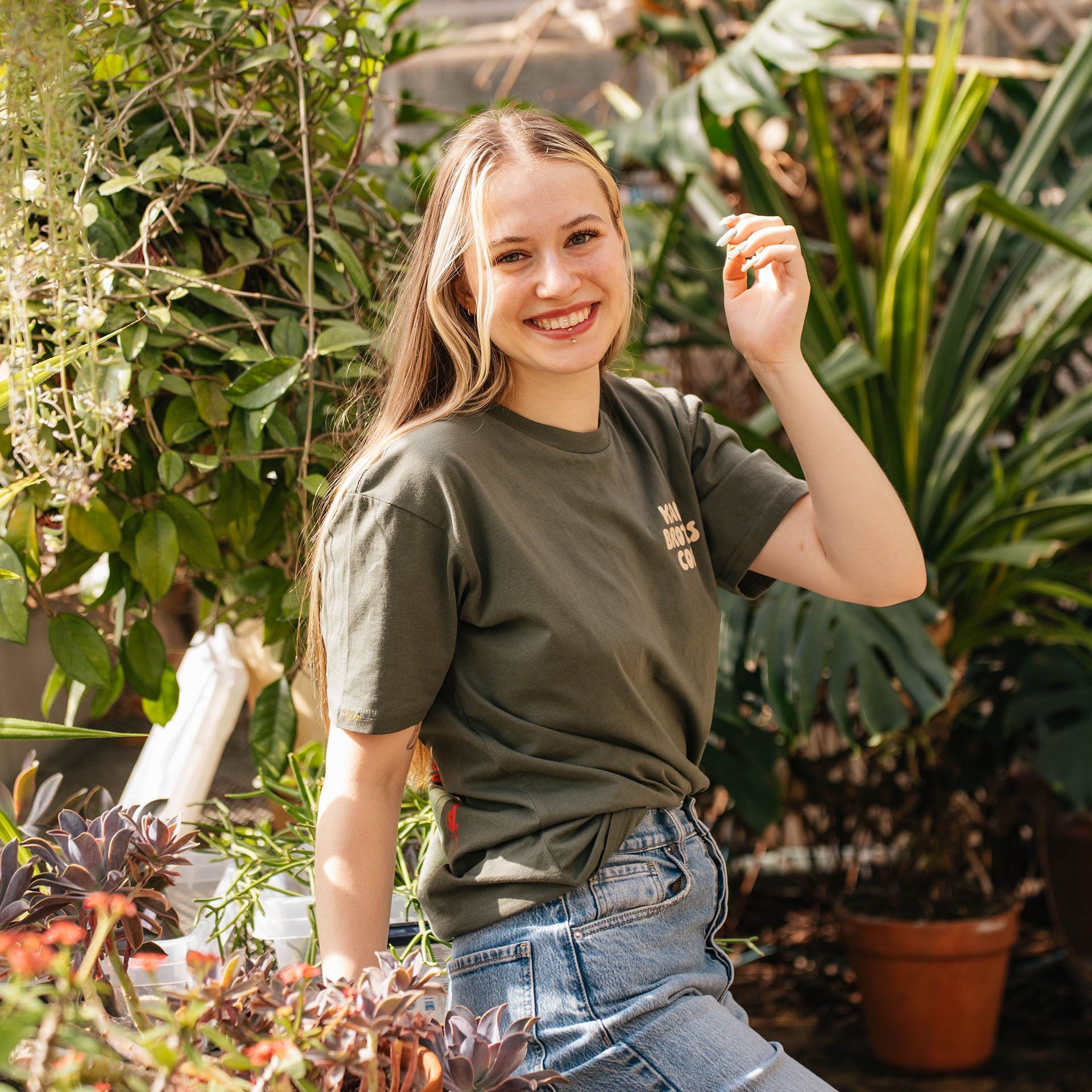 Woman wearing the olive Coffee Cherry T-Shirt in a greenhouse