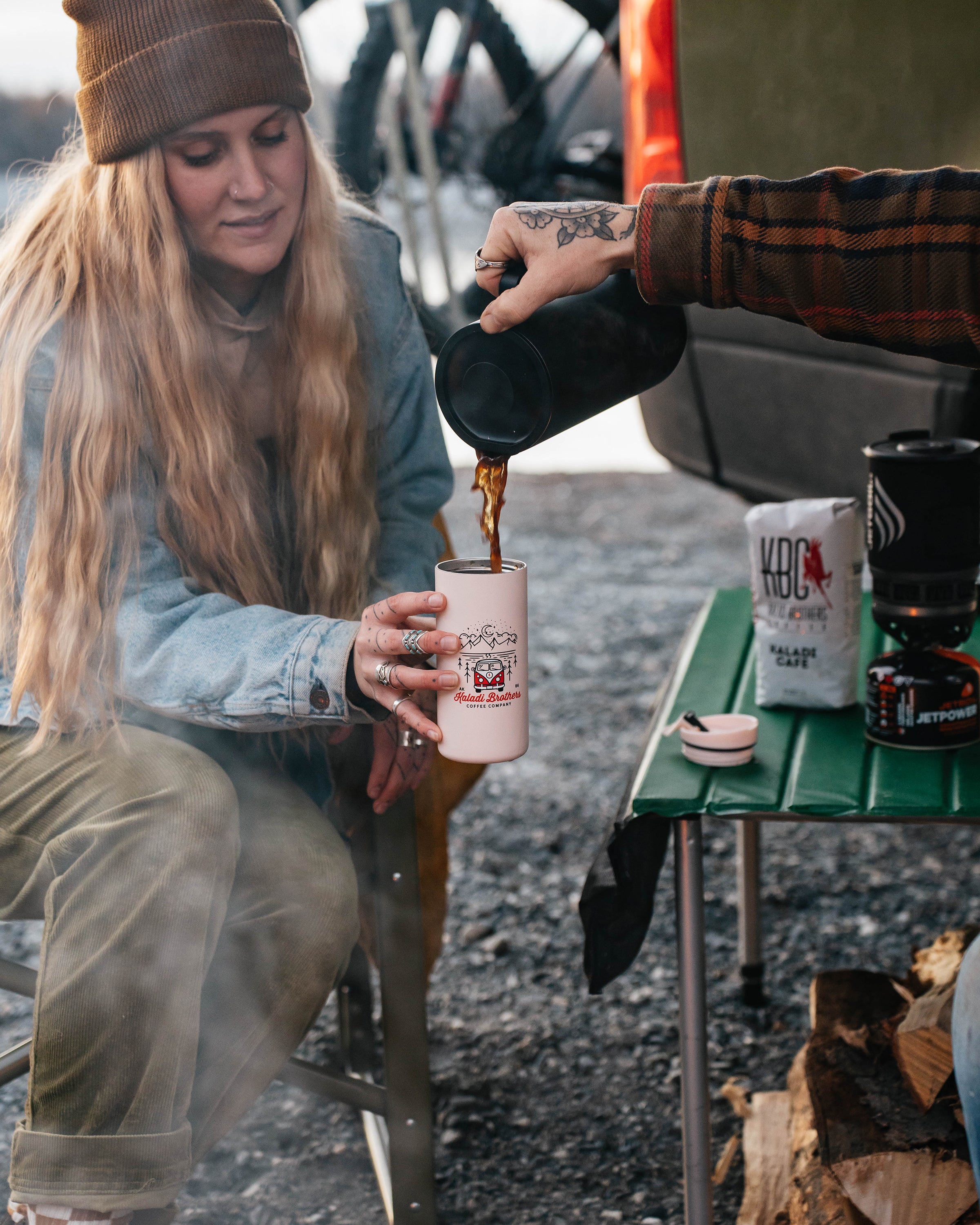 Woman pouring coffee from the MiiR French press at a campsite