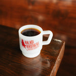 White 8oz milk glass mug of black coffee with red Kaladi logo