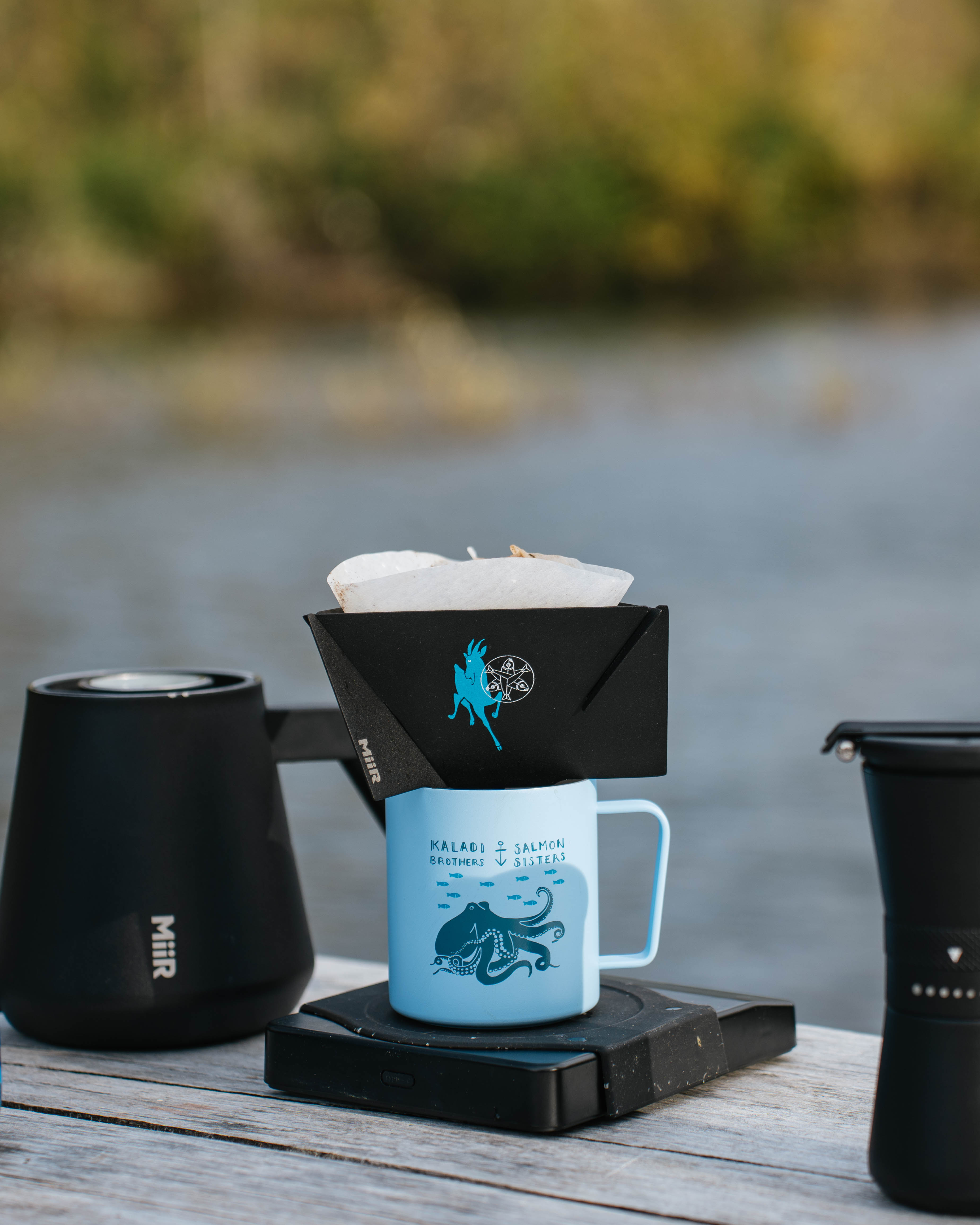 MiiR Pourigami dripper brewing on a blue camp mug riverside