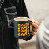 Person holding the navy Kaladi camp cup filled with a latte