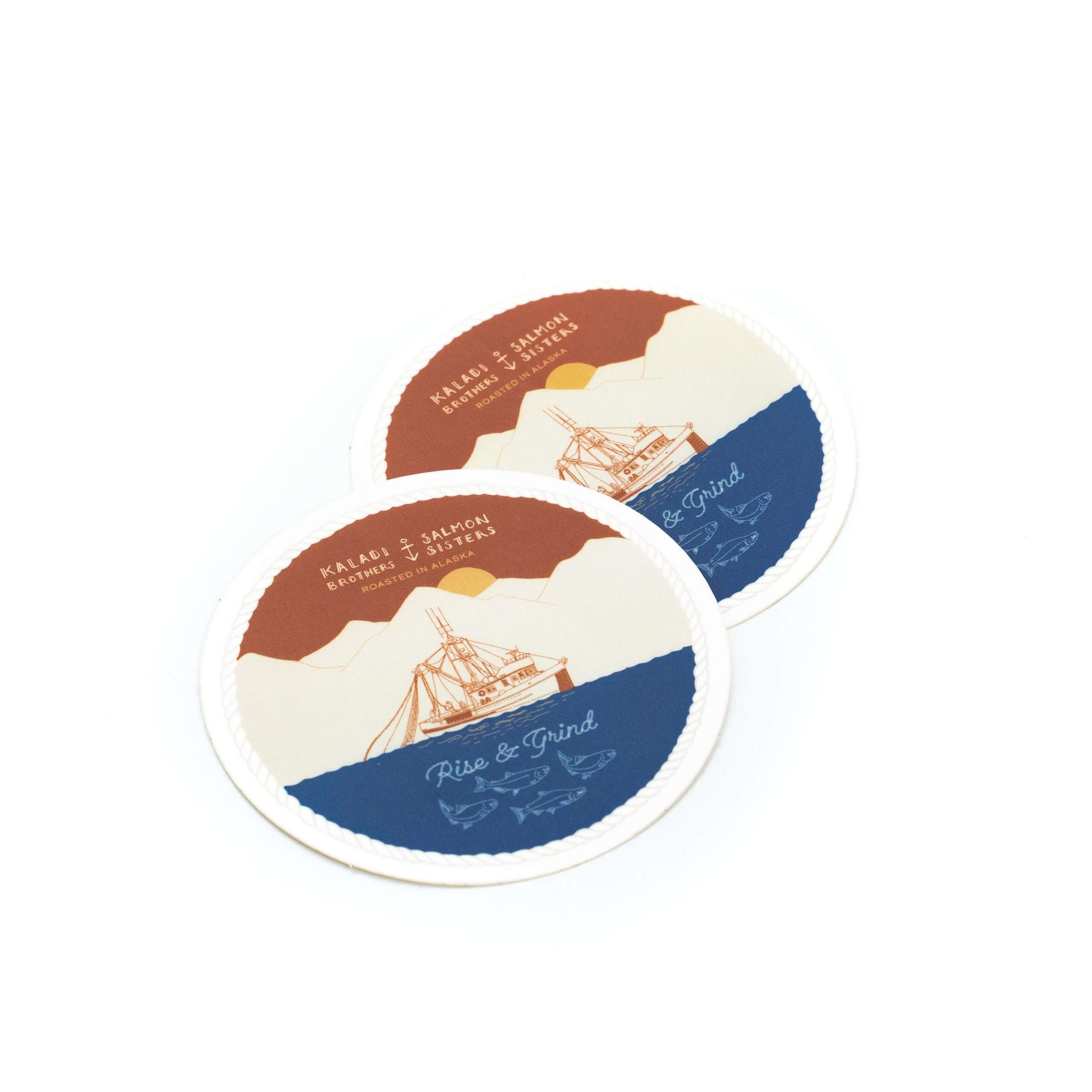Two round Rise & Grind stickers with sailing ship artwork