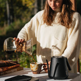 Making pour-over coffee with the black MiiR kettle at an outdoor table