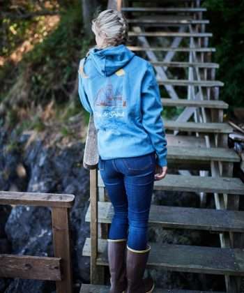 Kaladi Brothers Coffee A woman wearing a Rise & Grind Hoodie standing on a set of stairs.